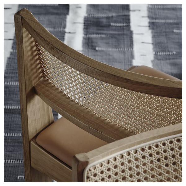 Una silla de madera de alta calidad con respaldo tejido y asiento acolchado, destacando su durabilidad y elegante diseño.