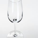 Copa de vino transparente con tallo largo, acabado liso, sobre fondo blanco. Material cristalino, que refleja la luz con elegancia.