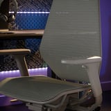 Silla gaming moderna con respaldo de malla, diseño ergonómico, color gris y ajustable.