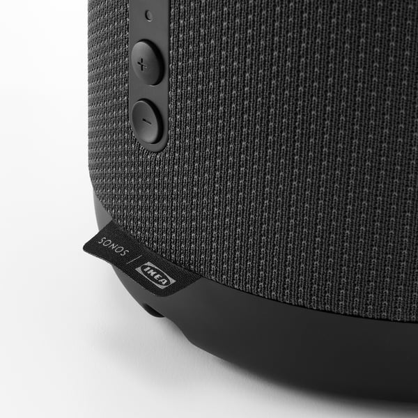 Altavoz negro cubierto de tela con botones de control, "sonos" y pestaña de la marca "IKEA".