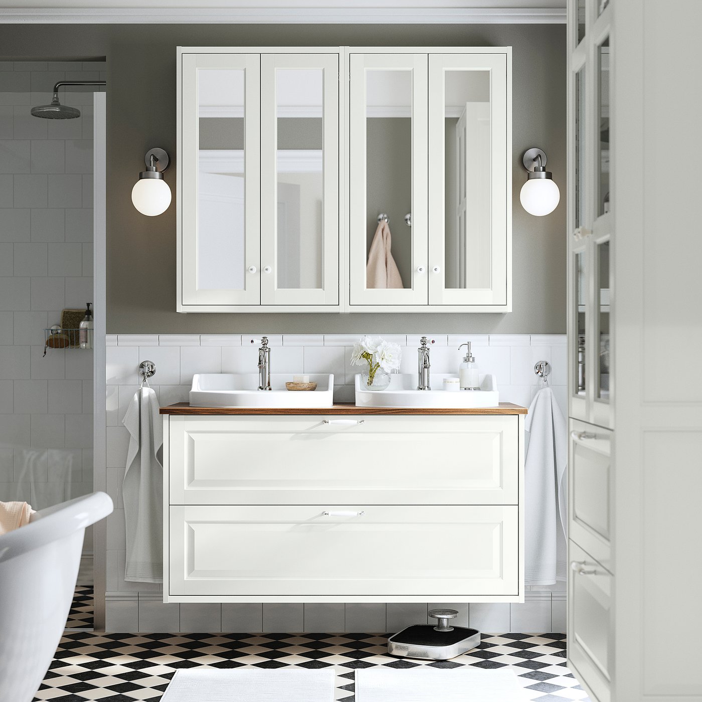 Baño moderno con armarios TÄNNFORSEN blancos con espejos, lavabos y suelo de tablero de ajedrez.