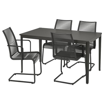 Un juego de comedor negro con una mesa cuadrada y cuatro sillas a juego. Las sillas tienen reposabrazos y asientos tejidos.