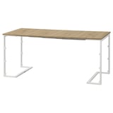 Una mesa de comedor convertible TRÄKUMLA en color marrón claro con estructura de metal blanco, diseñada para espacios pequeños.
