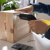 La persona usa un destornillador inalámbrico TRIXIG en muebles de madera; La empuñadura de goma y la luz LED ayudan a un montaje preciso.