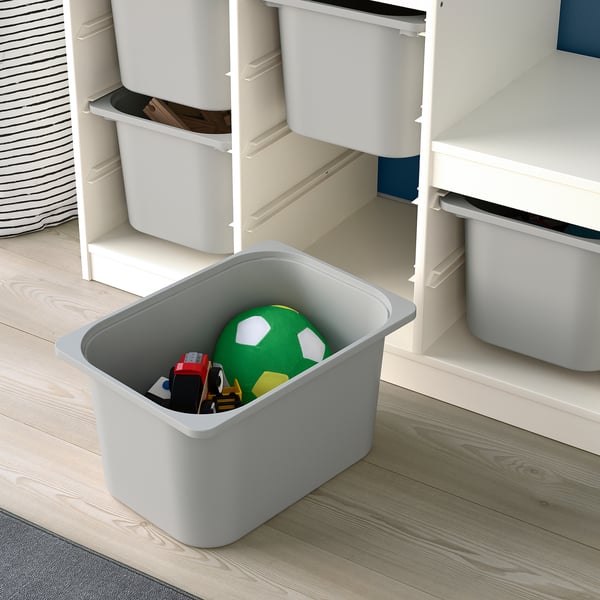Caja de almacenamiento en el suelo con juguetes, parte de la serie TROFAST para habitación infantil.