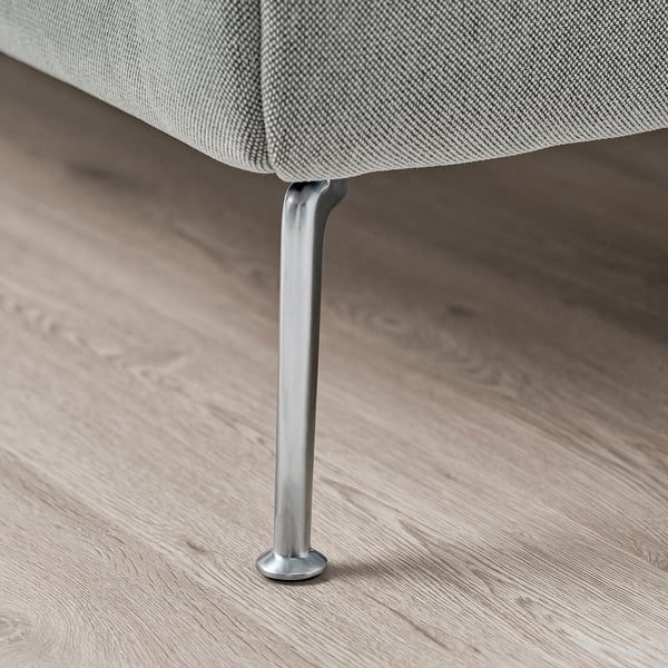 Primer plano de la pata de una cama tapizada gris sobre suelo de madera. Recorte para mayor estabilidad, diseño elegante.