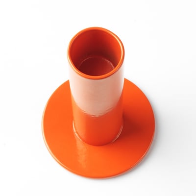 Candelabro de acero naranja brillante con base ancha, bordes lisos e interior hueco. Forma parte de la colección nytillverkad de ikea.