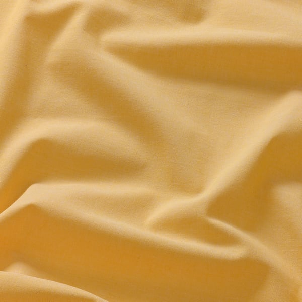 Un primer plano de un tejido suave de color amarillo dorado con una textura sutil, que muestra su superficie lisa y ligeramente irregular, insinuando un material de alta calidad.