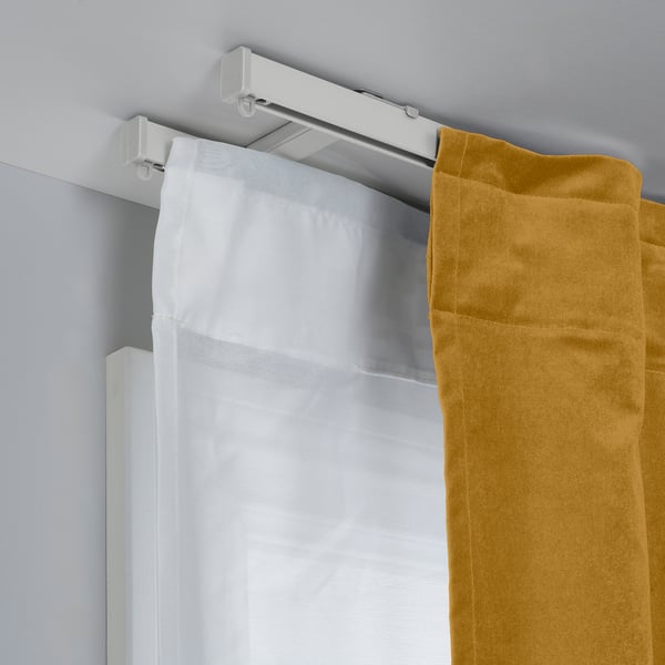 La imagen muestra los soportes de cortina montados en el techo VIDGA que sostienen dos cortinas, lo que demuestra una solución de cortina de 2 capas para el control de la luz y la privacidad.