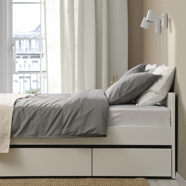 Marco de cama minimalista con dos cajones de almacenamiento debajo de la cama para ropa de cama adicional. Ruedas para un fácil despliegue.