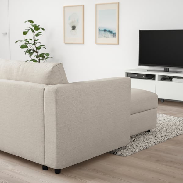 Sala de estar moderna: sofá VIMLE beige con tumbona, TV de pantalla plana, decoración blanca, planta y alfombra.