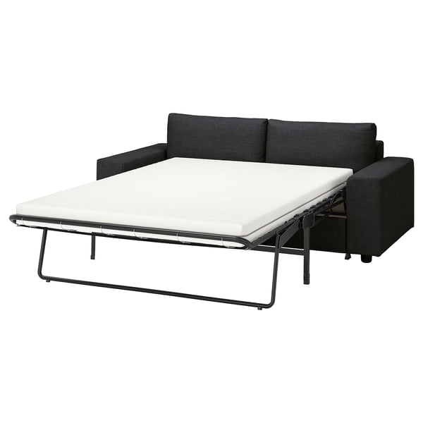 Elegante sofá cama negro VIMLE abierto con cojín blanco, diseño moderno.