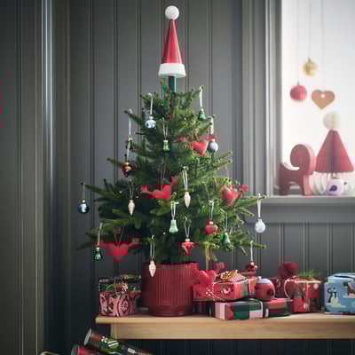 Mini árbol de Navidad rojo VINTERFINT con adornos de corazón, pequeños regalos y gorro de Papá Noel en una habitación decorada.