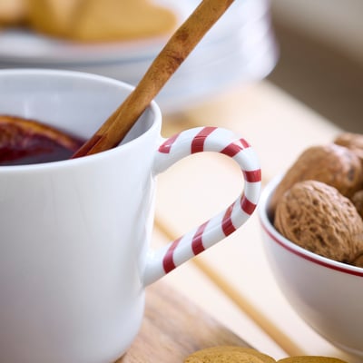 Taza VINTERFINT blanca, asa de rayas rojas, fabricada en porcelana.