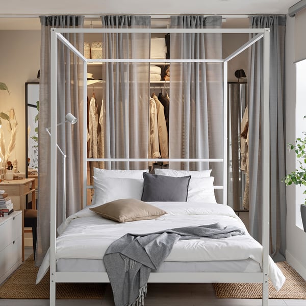 Dormitorio moderno con cama con dosel VITARNA, ropa de cama gris, armario y escritorio.