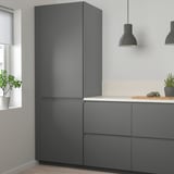 Cocina moderna con armarios de color gris oscuro y nevera grande.