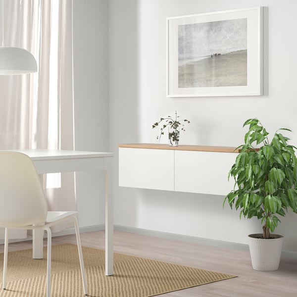Aulkia, landarea eta artelanak dituen idazmahai zuri minimalista, espazio modernoetarako egokia.