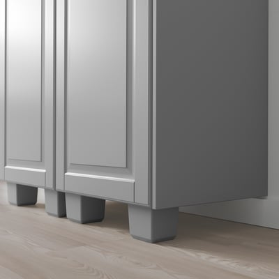 Sukaldeko armairu grisak, panel biselatuak eta oin estugarriak zoru irregularretarako.