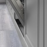 Sukaldeko altzariaren xehetasuna, ertz biselatuak eta kabinetearen azpian zakaloa duten BODBYN panel gris garbiekin.