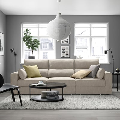 Egongela modernoa, sofa eskilstuna, erdiko mahaia, alfonbra, lanpara esekia eta leihoak dituena.