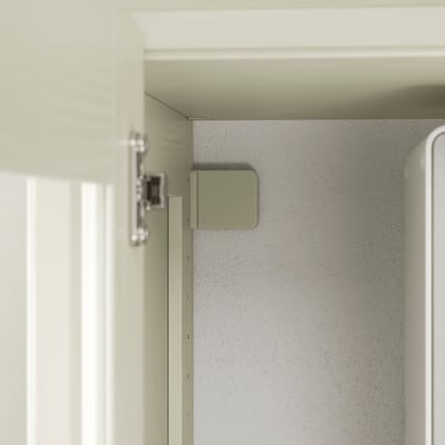 Armairuaren bisagra hurbila, metalezko bisagra eta gainazal margotu leunekin eraikuntza kalitatezkoa erakusten duena.