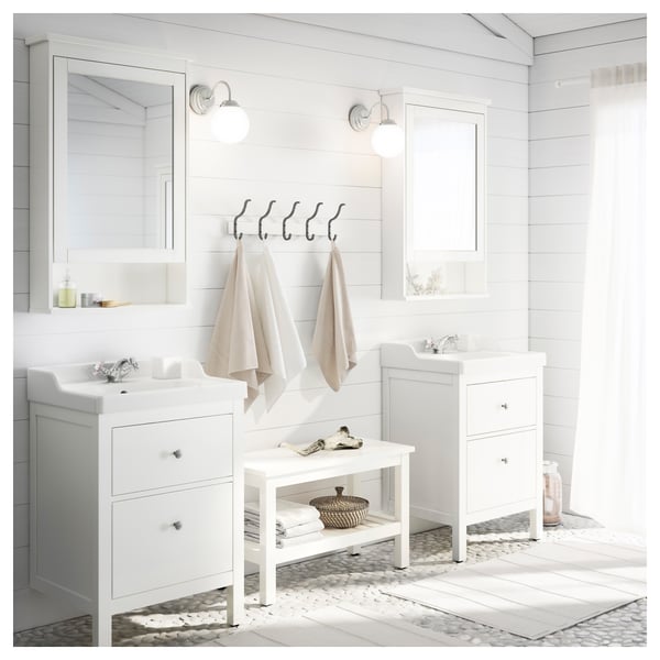 Bainu modernoa HEMNES ukigailuekin, ispiluekin, bankuarekin, pisu grisarekin, beige eskuoihalekin eta hormako kakoekin. Diseinu argitsua eta minimalista.