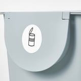 Pegatina edukiontzi gris argiaren estalkian, zaborrentzako lerro sinpleko marrazki-ikur batekin.