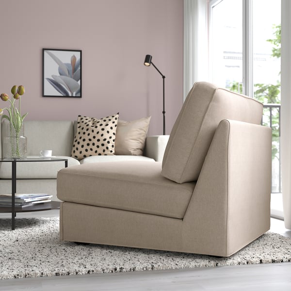 Egongela moderno bat, KIVIK beige ohe sofa batekin, ilargi-burko batekin, beirazko mahai batekin eta leiho handi batekin.