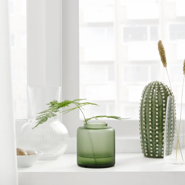 Lau pitxer bakar leiho bateko leihoan, ingurune minimalista batean loreak eta landaretza erakusten dituztenak. Bi pitxer garden, bata berde esmerilatua eta bestea berdea.