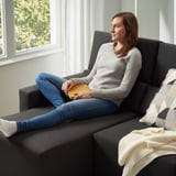 Emakumea sofa estugarrian, irakurketa liburua. Edo, jatorrizkotik hurbilago egoteko: emakumea sekzional doigarrian, irakurtzen.