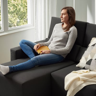 Emakumea sofa estugarrian, irakurketa liburua. Edo, jatorrizkotik hurbilago egoteko: emakumea sekzional doigarrian, irakurtzen.