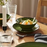 Zeramika berdezko katilua platerean, zitriko entsaladarekin, pepinoa; labana, koilara, edalontziak, kandela.
