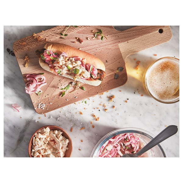 Sandwich gourmet bat garagardoarekin eta kondimentuekin mozteko taula batean.
