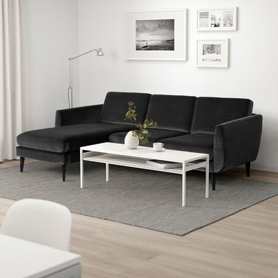 Egongela modernoa sofa modular gris ilunarekin, zentro zuriko mahaiarekin eta dekorazio minimalistarekin.