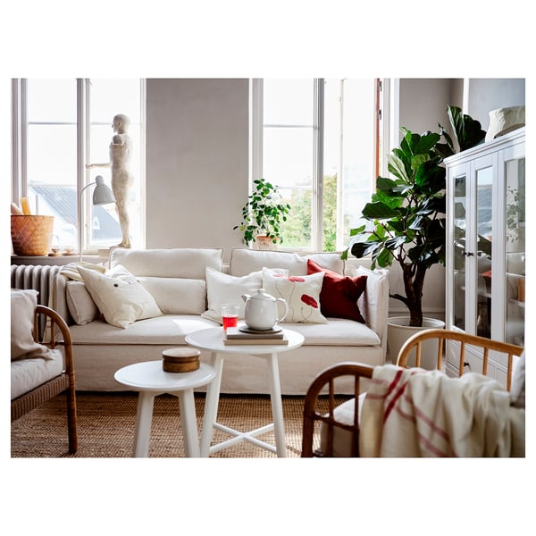 Egongela argitsua sofa zuria, landareak eta argi naturalarekin.