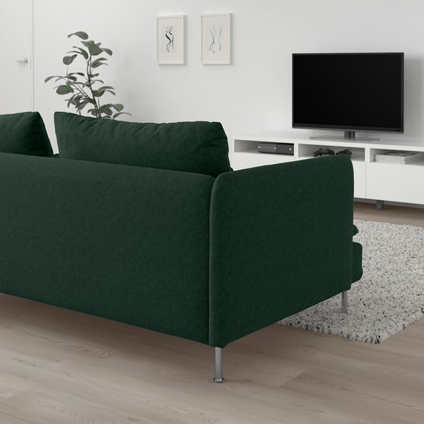 Sofa berdea SÖDERHAMN, egurrezko zoru argiaren gainean, telebista eta landarearekin. Kuxin sakonak eta solteak, diseinu dotore eta aireztatua. Sofa beste artikulu batzuk baino handiagoa da.