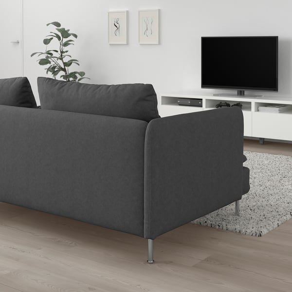 Sofa modernoa egongelan, gris iluna eserleku sakonarekin eta hanka altuekin.
