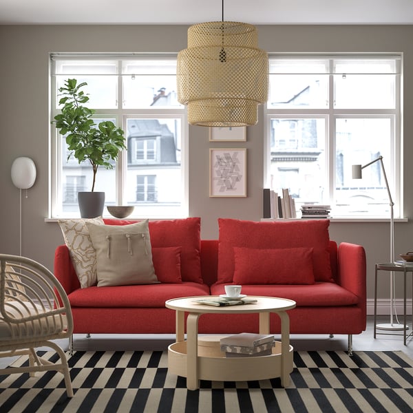 Sofa SÖDERHAMN gorria, alfonbra, leiho handia, erdi-mahaia egongela modernoan.