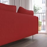 Sofa gorria, landaredun leihotik gertu, erosotasuna eta estiloa eskaintzen dituena.