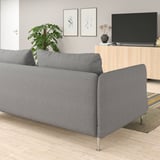 Sofa SÖDERHAMN grisa, diseinu minimalista modernoa, eserleku sakonak, egurrezko zoru argi eta azentu-landarea dituen gela zabal batean.