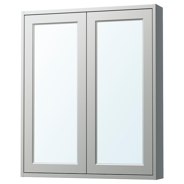 Ispilu gris argia eta TÄNNFORSEN-en panel biselatuak dituen hormako armairu bat.