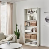 TÄTING ratan-saskia duen egongela billy apalean, sofa, mahai eta kaktusaren ondoan.