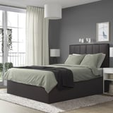 Cama TJßLLE modernoa, gris iluna, izara berdeekin, handia horma urdinaren kontra. Buruko akoltxatua eta gaueko lanparak ditu. Alfonbra eta balkoi ikusiak.