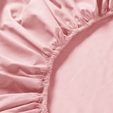 Ertz elastikoekin estututako ehun arrosa leuneko lehen planoa, perkal garbizko ehun bat eta ehundura leun bat erakusten dituena.