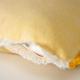 Kolore hori distiratsuko kojinezko zorro bat, fleko zuriekin eta kremailera batekin, ehundura ehundura ehuntzen duen oihal bat erakusten duena.