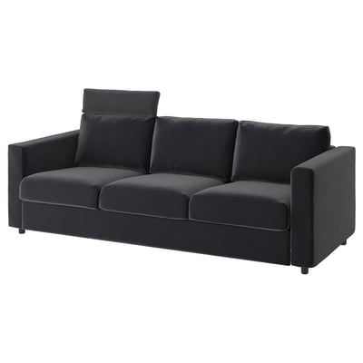 Sofa moderno bat gris ilunean. Diseinu dotorea, hiru kuxin eta erosotasun handiagoko burua ditu.