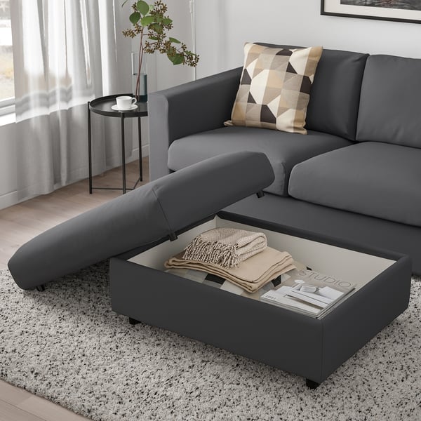 Egongela modernoa, VIMLE gris sofa sekzionalarekin, mantaz eta aldizkariz betetako biltegi irekiko konpartimentua duen atsedena.