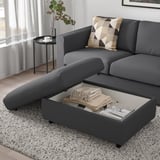 Egongela modernoa, VIMLE gris sofa sekzionalarekin, mantaz eta aldizkariz betetako biltegi irekiko konpartimentua duen atsedena.