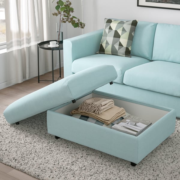 Sofa VIMLE urdin argia otomanarekin, manta eta aldizkarien biltegiratzea, argiz betetako egongela.