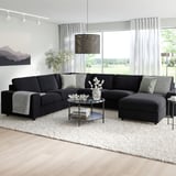 Egongela moderno bat, VIMLE sofa sekzional beltza, kafe-mahai bat, alfonbra bat eta kuxinak dituenak.